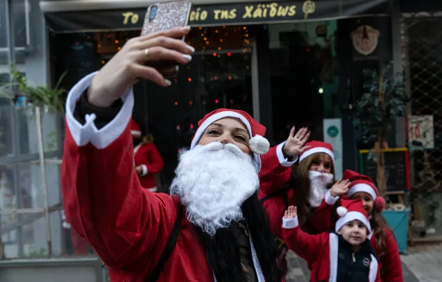 People dressed as Santa Claus pose for a selfie at the Santa Run in Piraeus, Greece on December 19, 2021. The center of Piraeus, Greece's port, turned red on Sunday, as over 1,000 people of all ages dressed in Santa Claus costumes participated in the Piraeus 2021 Santa Run. (Photo by Xinhua News Agency/Rex Features/Shutterstock)