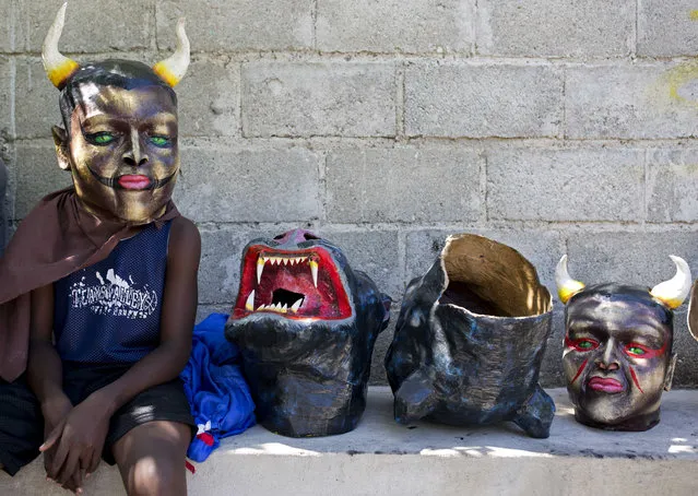 A masked performer waits for his friends before a Carnival parade in Les Cayes, Haiti, Tuesday, February 28, 2017. (Photo by Dieu Nalio Chery/AP Photo)