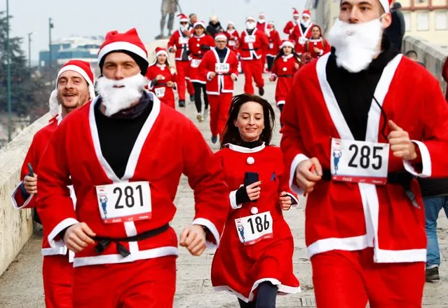 People dressed as Santa Claus run during the annual Santa race competition in Skopje, North Macedonia, December 26, 2021. (Photo by Ognen Teofilovski/Reuters)