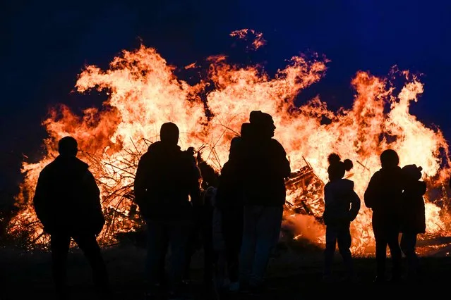 Revellerslook at a bonfire, as Bulgarians celebrate Mesni Zagovezni, an Orthodox Christian holiday during which they chase away evil spirits with fire rituals, in the village of Lozen, some 15km southwest of Sofia, on March 10, 2024. (Photo by Nikolay Doychinov/AFP Photo)
