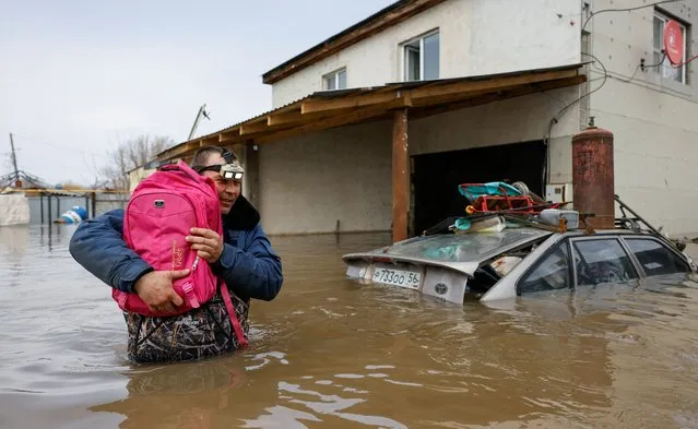 Resident Dmitry Dragoshantsev carries a backpack with his cats out of his flooded house in Orenburg, Russia, on April 12, 2024. (Photo by Maxim Shemetov/Reuters)
