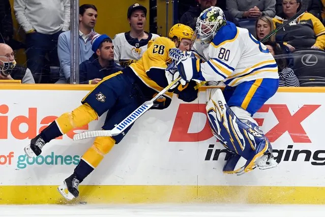 Nashville Predators right wing Eeli Tolvanen (28) collides with Buffalo Sabres goaltender Aaron Dell (80) during the second period of an NHL hockey game Thursday, January 13, 2022, in Nashville, Tenn. Dell was attempting to clear puck away from Predators defenders. (Photo by Mark Zaleski/AP Photo)