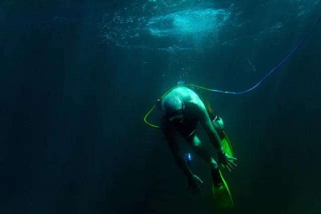 Paul Kuntne tries to dive down as he Snuba's for the first time off the coast of Roatan, Honduras on December 25, 2012. Snuba is an underwater breathing system. The air, however, instead of coming from tanks strapped to the diver's back, comes through a long hose from tanks on pontoon rafts on the surface. Paul retired from the Coast Guard where he served as part of the Presidential Honor Guard. (Photo by Master Sgt. Jeremy Lock/U.S. Air Force)