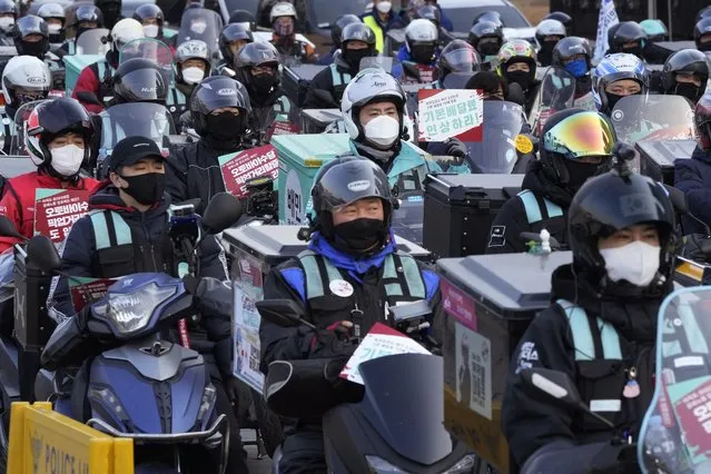 Food delivery riders wearing face masks to help protect against the spread of the coronavirus stage a rally to demand better working conditions in Seoul, South Korea, Thursday, December 23, 2021. South Korea has set a new record for daily COVID-19 deaths as it struggles to resolve a shortage of hospital beds amid weeks of surging cases. (Photo by Ahn Young-joon/AP Photo)