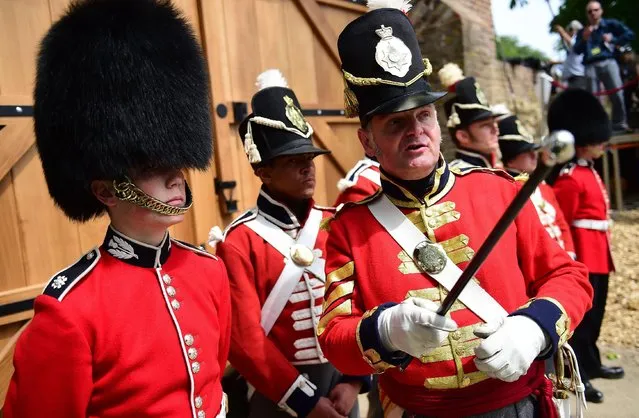 Troops stand in front of the new North Gate during the ceremonial opening of Hougoumont Farm in Braine-l'Alleud, near Waterloo, Belgium on Wednesday, June 17, 2015. Hougoumont Farm played a critical role in the outcome of the Battle of Waterloo, and the newly restored farm will open to the general public on June 18, 2015. (AP Photo/Emmanuel Dunand/Pool Photo via AP)
