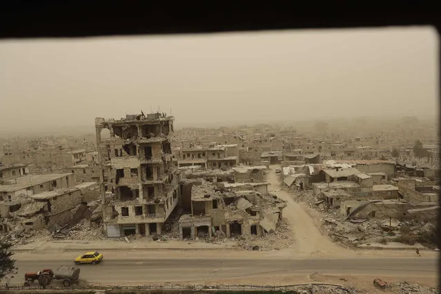 A view during a sandstorm shows destruction in the once rebel-held Karm al-Jabal neighbourhood on March 9, 2017. (Photo by Joseph Eid/AFP Photo)