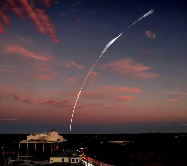 A long exposure shows the trajectory of the SpaceX Falcon 9 rocket lifting off from Kennedy Space Center, Fla., over the Orlando Science Center observatory at dusk, Monday, January 31, 2022. The SpaceX launch deployed a COSMO-SkyMed Second Generation FM2 satellite, operated by the Italian Space Agency. (Photo by Joe Burbank/Orlando Sentinel via AP Photo)