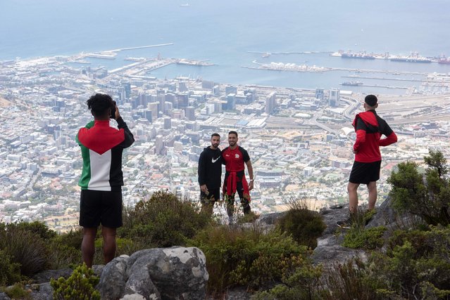 Palestinian national football team defenders Bashar Shobaki (C-L) and Ali Rabei (C-R) pose for a photograph from the top of Table Mountain, in Cape Town, on February 15, 2024. (Photo by Rodger Bosch/AFP Photo)