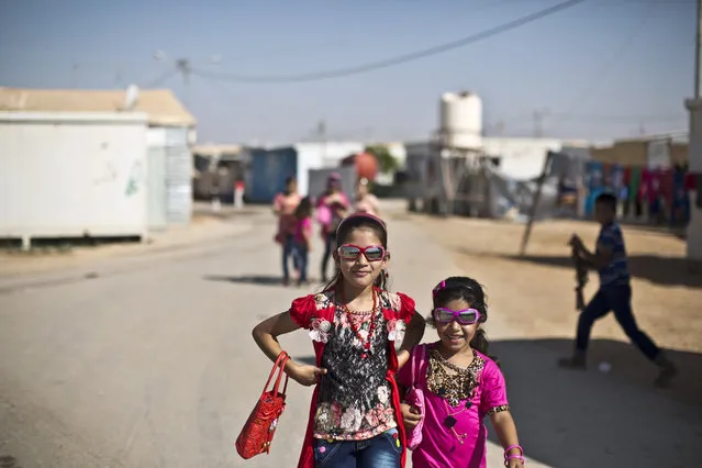 Syrian girls dressed in new clothes celebrate the first day of the Eid al-Fitr holiday that marks the end of the holy fasting month of Ramadan at Zaatari refugee camp, in Mafraq, Jordan, Friday, July 17, 2015. (Photo by Muhammed Muheisen/AP Photo)