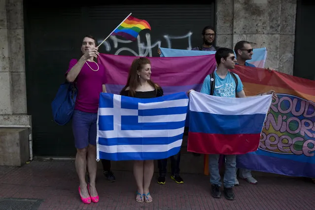 Protesters from a Greek gay and lesbian rights group  hold a Greek and a Russian flag in front of parliament, to protest a visit by Russian President Vladimir Putin, on Friday, May 27, 2016. (Photo by Petros Giannakouris/AP Photo)