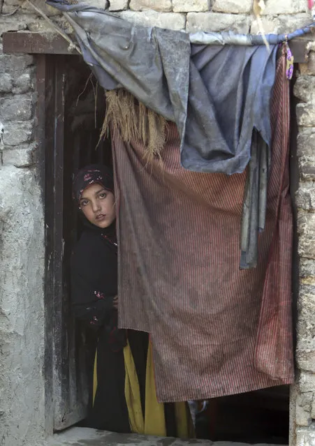 In this Sunday, March 19, 2017 photo, a young women looks on through a door in her home in Kabul, Afghanistan, Sunday, March 19, 2017. An aid group says nearly a third of all children in war-torn Afghanistan are unable to attend school, leaving them at increased risk of child labor, recruitment by armed groups, early marriage and other forms of exploitation. (Photo by Massoud Hossaini/AP Photos)