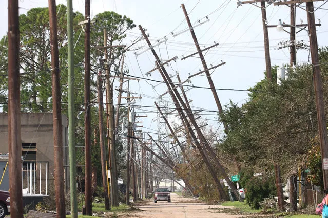 Utility poles lean over a street following Hurricane Ida on August 31, 2021 in Houma, Louisiana. Ida made landfall August 29 as a Category 4 storm southwest of New Orleans, causing widespread power outages, flooding and massive damage. (Photo by Scott Olson/Getty Images)