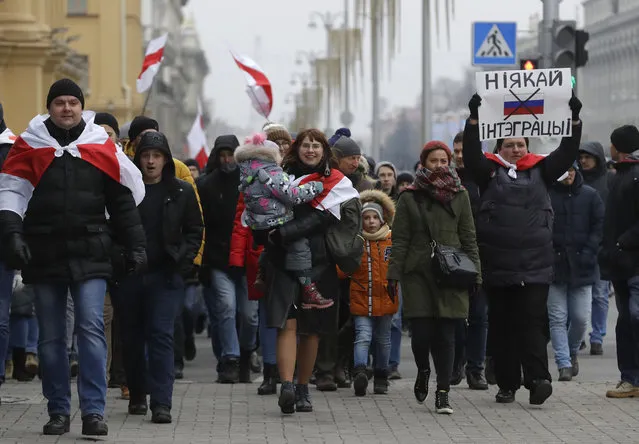 Protesters attend the procession in downtown Minsk, Belarus, Saturday, December 7, 2019. More than 1,000 opposition demonstrators are rallying in Belarus to protest closer integration with Russia. Saturday's protest in the Belarusian capital comes as Belarusian President Alexander Lukashenko is holding talks with Russian President Vladimir Putin in Sochi on Russia's Black Sea coast. (Photo by Sergei Grits/AP Photo)