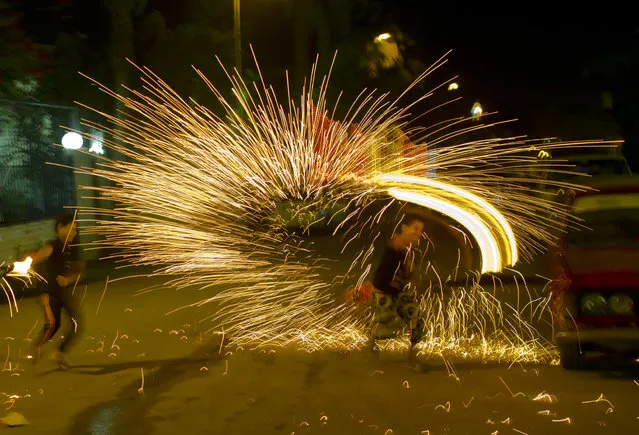 In this late Tuesday, June 7, 2016 picture, Egyptians play with fire works as they celebrate the holy month of Ramadan in Cairo, Egypt. Devout Muslims throughout the world began to celebrate Ramadan, the holiest month in the Islamic calendar, refraining from eating, drinking, smoking and sеx from sunrise to sunset. (Photo by Amr Nabil/AP Photo)