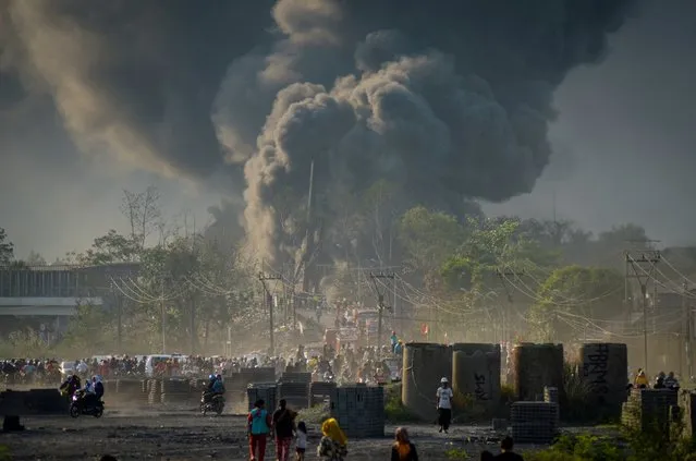 Locals watch as smoke rises from a fire on a pipeline owned by PT Pertamina in Cimahi near Bandung, West Java province, Indonesia on October 22, 2019 in this photo taken by Antara Foto. (Photo by Raisan Al Farisi/Antara Foto via Reuters)