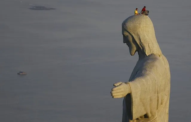 Men work on repairs on the Christ the Redeemer statue, in Rio de Janeiro June 27, 2014. (Photo by Ricardo Moraes/Reuters)
