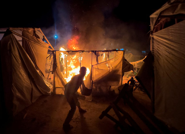 Palestinians work to extinguish a fire at the site of an Israeli strike on a tent camp for displaced people, amid the Israel-Hamas conflict, in Deir Al-Balah in the central Gaza Strip on August 3, 2024. (Photo by Abdullah Al-Attar/Reuters)