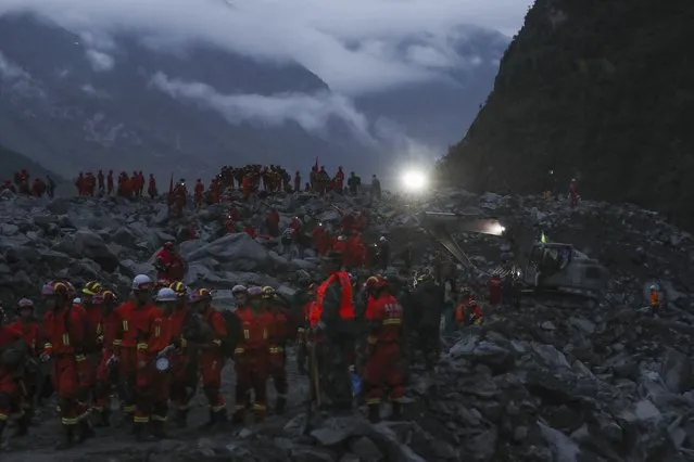 In this June 24, 2017 photo released by China's Xinhua News Agency,  rescuers work at the accident site after a landslide occurred in the mountain village of Xinmo, Maoxian county, in southwestern China's Sichuan Province. Crews searching through the rubble left by a landslide that buried a mountain village under tons of soil and rocks in southwestern China on Saturday found more than a dozen of bodies, but more than 100 more people remained missing. (Photo by Jiang Hongjing/Xinhua via AP Photo)