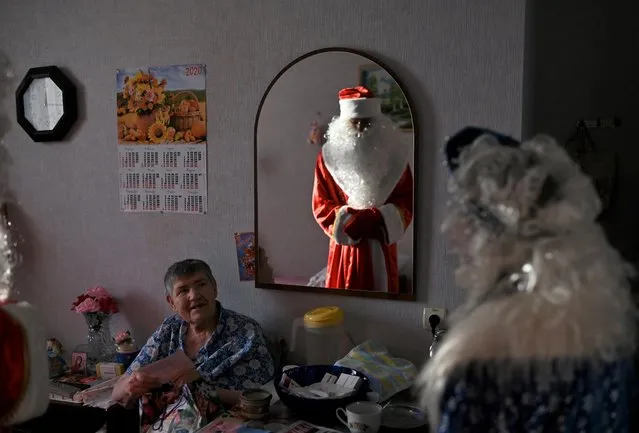 Volunteers dressed as Father Frost and Snow Maiden present a gift to a resident of a nursing home on the occasion of the Christmas and New Year holidays, as part of the “Old Age for Joy” charity project, in the village of Sosnovskoye in Omsk region, Russia on December 28, 2019. (Photo by Alexey Malgavko/Reuters)