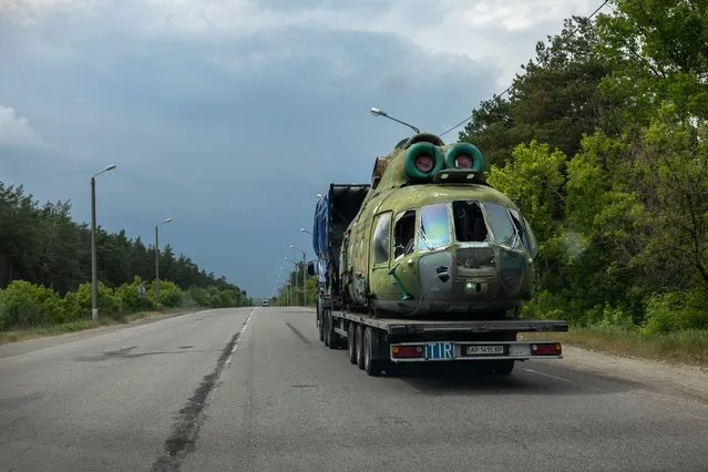 The body of a shattered Ukrainian military helicopter is transported on May 21, 2022 in Kharkiv, Ukraine. In recent days Russian troops have been counterattacking Ukrainian troops in the northern suburbs of Kharkiv, Ukraine's second largest city. (Photo by John Moore/Getty Images)