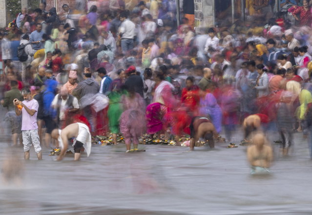 Nepalese devotees gather at the Bagmati River to commemorate their deceased fathers at the sacred shrine of Lord Shiva, Gokarneswor Shrine, near Kathmandu, Nepal, 02 September 2024. On Father's Day, sons and daughters show their gratitude to their fathers, bringing them presents, sweets and fruits. Those who no longer have a father, traditionally visit Gokarneswor Shrine where they conduct puja and offer “Pinda” – food for the departed soul and pray for his eternal peace. IPhoto by Narendra Shrestha/EPA)