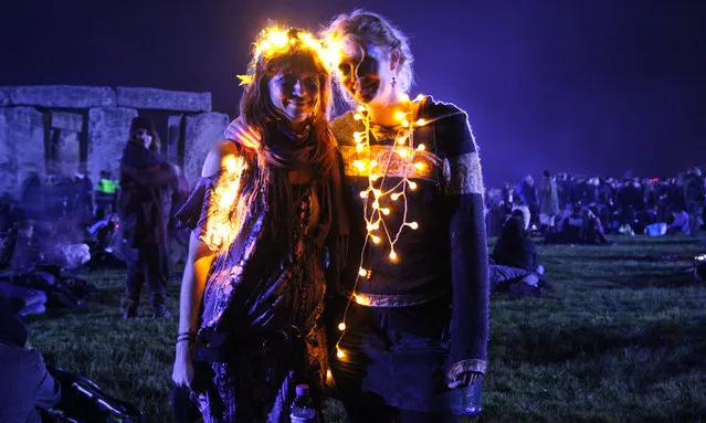 Two fairy light-clad visitors brighten up the darkness during the summer solstice at the Stonehenge in Wiltshire, Britain, on June 21, 2016. (Photo by Natasha Quarmby/Rex Features/Shutterstock)