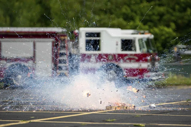 A demonstration of a lithium battery fire 1/300th the size of what is in a passenger vehicle explodes as firefighters with the Huntington Fire Department receive electric vehicle fire training on Thursday, June 2, 2022, at the Tri-State Fire Academy in Huntington, W.Va. (Photo by Sholten Singer/The Herald-Dispatch via AP Photo)