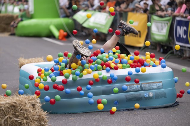 A participant falls during the Office Chair Race World Cup (Buerostuhlrennen Weltmeisterschaft), in Olten, Switzerland, 01 July 2023. (Photo by Anthony Anex/EPA)