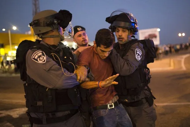 Israeli police officers detain a Palestinian activist during a protest in support of a hunger-striking Palestinian prisoner, Mohammed Allan, in the southern city of Ashkelon August 16, 2015. (Photo by Amir Cohen/Reuters)