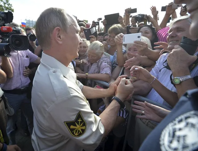 Russian President Vladimir Putin (L, front) meets with people after submerging into the waters of the Black Sea inside a research bathyscaphe as part of an expedition in Sevastopol, Crimea, August 18, 2015. (Photo by Alexei Druzhinin/Reuters/RIA Novosti/Kremlin)