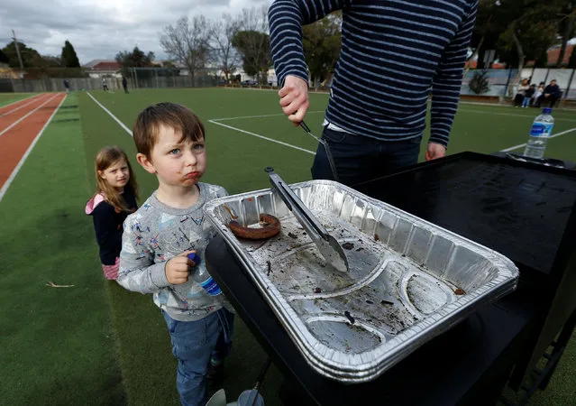 A boy looks at a grilling try with just one sausage remaining after a vendor sold out of traditional sausage sandwiches outside a polling station at Moonee Ponds West Primary School in Melbourne, July 2, 2016 on Australia's federal election day. (Photo by Jason Reed/Reuters)