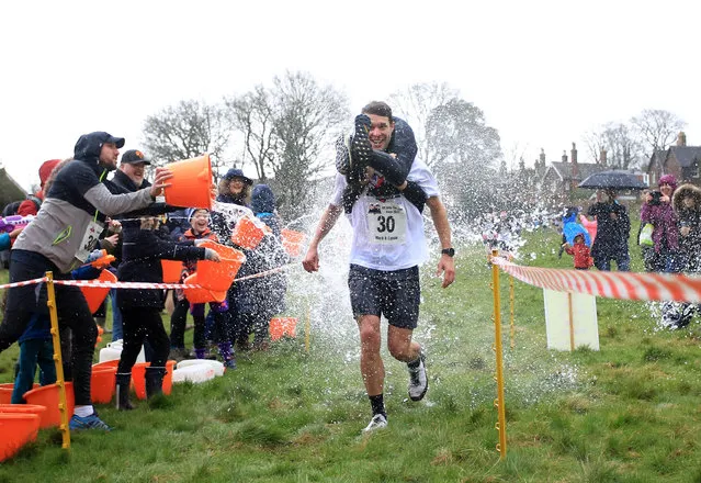 Mark Threlfall and Cassie Yates compete in the annual wife-carrying race in Dorking, England on March 1, 2020. (Photo by Rex Features/Shutterstock)