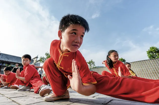 Children from a Shaolin martial art institute practise kung fu at a village in Suichuan County on August 13, 2017 in Ji'an, Jiangxi Province of China. (Photo by VCG/VCG via Getty Images)