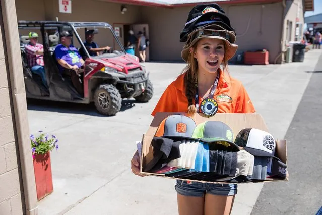 Avery Oppenlander sells eclipse souvenir products as eclipse enthusiasts gather in Madras, Oregon, on August 18, 2017. The rural central and eastern part of Oregon is hosting dozens of festivals to help manage the crowds – a million visitors are expected to the region for the Monday August 21, 2017, natural phenomena. (Photo by Rob Kerr/AFP Photo)