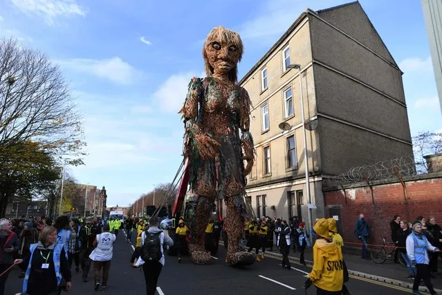 Storm, a 10 metre tall “goddess of the sea” puppet who carries a message of the oceans in crisis, moves through the streets of Glasgow on November 10, 2021, during the COP26 UN Climate Change Conference. A draft text at the COP26 climate summit urged countries on Wednesday to boost their emissions cutting goals by 2022, three years ahead of schedule, after data showed the world was far off track to limit warming to 1.5C. (Photo by Paul Ellis/AFP Photo)