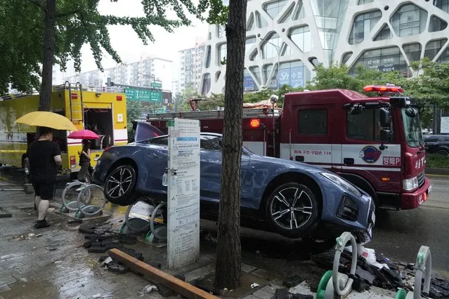 A vehicle sits damaged on a road after floating in heavy rainfall in Seoul, South Korea, Tuesday, August 9, 2022. (Photo by Ahn Young-joon/AP Photo)