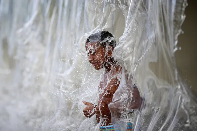 A child plays with water inside the Madureira Park ahead of the Rio 2016 Olympic Games in Rio de Janeiro, Brazil, July 17, 2016. (Photo by Ueslei Marcelino/Reuters)