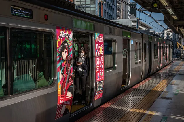 A woman wearing a face mask checks her phone as she waits for a train to depart on April 6, 2020 in Tokyo, Japan. Japan's Prime Minister, Shinzo Abe, today announced that the government would declare a state of emergency as soon as Tuesday that would cover 7 of Japans 47 prefectures, including Tokyo and Osaka, as the Covid-19 coronavirus outbreak continues to spread in the country. The move will allow affected prefectures to take measures including expropriating private land and buildings and requisitioning medical supplies and food from companies that refuse to sell them. (Photo by Carl Court/Getty Images)