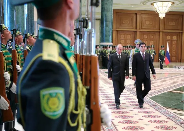 Russian President Vladimir Putin, center, and Turkmenistan's President, Gurbanguly Berdymukhamedov, review an honor guard prior to their talks in Ashgabat, Turkmenistan, Monday, October 2, 2017. Russian President Putin is meeting with the president of Turkmenistan on a rare visit to the gas-rich Central Asian nation. (Photo by Mikhail Klimentyev, Sputnik, Kremlin Pool Photo via AP Photo)