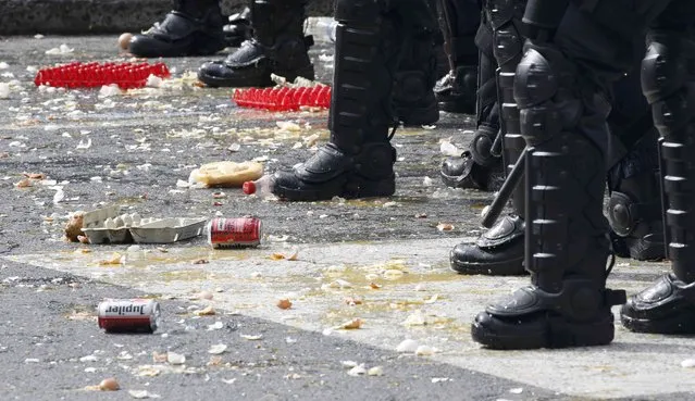 Eggs thrown by demonstrators are seen on the pavement as Belgian riot police officers stand guard as farmers and dairy farmers from all over Europe take part in a demonstration outside an European Union farm ministers emergency meeting at the EU Council headquarters in Brussels, Belgium, September 7, 2015. (Photo by Jacky Naegelen/Reuters)