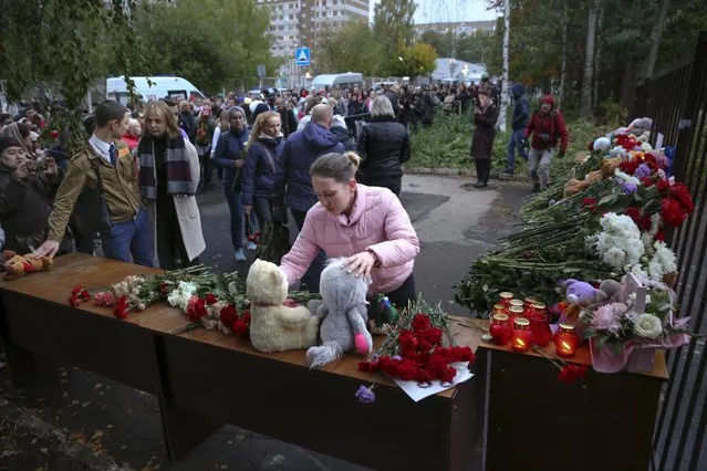 People gather to lay flowers, put toys and light candles in memory of victims of the shooting at school No. 88 in Izhevsk, Russia, Monday, September 26, 2022. (Photo by Sergei Kuznetsov/AP Photo)