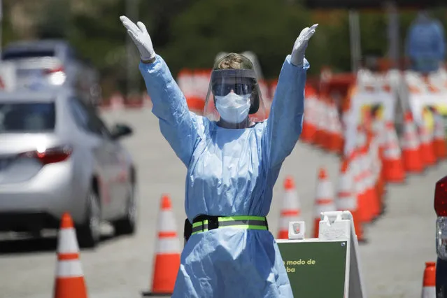 A worker directs traffic at a coronavirus testing site set up at Dodger Stadium Tuesday, May 26, 2020, in Los Angeles. (Photo by Marcio Jose Sanchez/AP Photo)