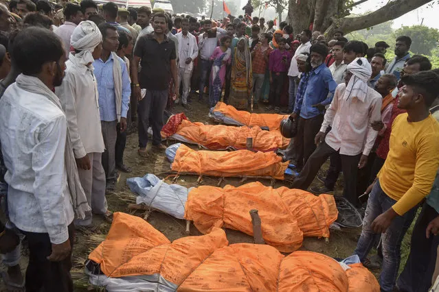 Villagers gather around the bodies of victims of a road accident in Kanpur, Uttar Pradesh state, India, Sunday, October 2, 2022. (Photo by AP Photo/Stringer)