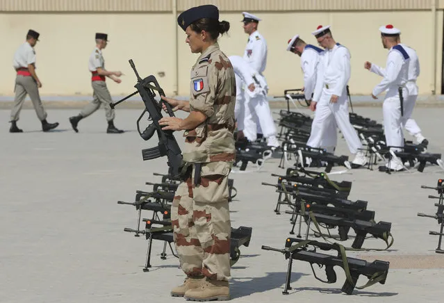 French military personnel take their guns after the French President leaves the naval base in Abu Dhabi, United Arab Emirates, Thursday, November 9, 2017. (Photo by Kamran Jebreili/AP Photo)