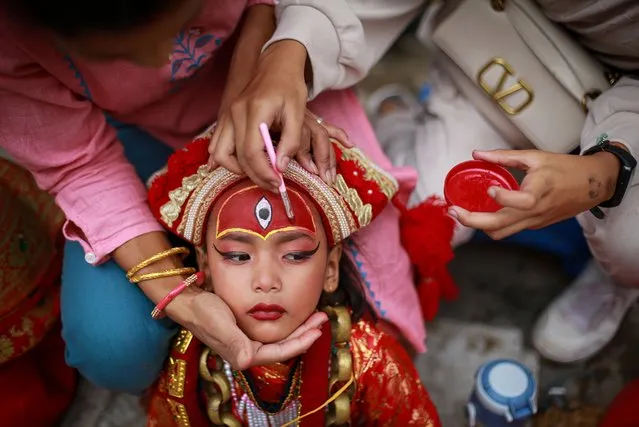 The parents of a little girl painting her forehead with a red paint to resemble the third eye of Living Goddess Kumari, which is believed to destroy all the evil in the world, at Basantapur Durbar Square, one of the UNESCO World Heritage Sites, on Thursday, September 8, 2022. Kumari Puja is a mass worship of little girls on the occasion of Indra Jatra, one of the the biggest religious street festival in Kathmandu. (Photo by Amit Machamasi/ZUMA Press Wire/Rex Features/Shutterstock)