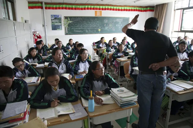 In this Friday, September 18, 2015 photo, Students follow a Tibetan-language lesson at the Lhasa-Beijing Experimental Middle School on the outskirts of Lhasa, capital of the Tibet Autonomous Region in China. The school, a brand new educational center for close to 2,500 students, was built by the Beijing municipal government as part of a national policy that pairs wealthy cities in eastern China with less developed ethnic regions of Xinjiang and Tibet in the west. (Photo by Aritz Parra/AP Photo)