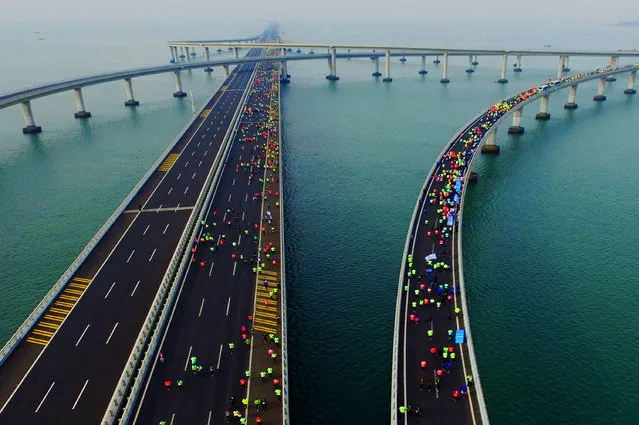 This photo taken on November 19, 2017 shows participants crossing the Jiaozhou Bay Bridge as they compete in the 2017 Qingdao International Marathon on the Sea in Qingdao in China's eastern Shandong province. (Photo by AFP Photo/Stringer)