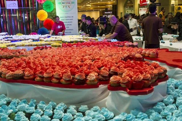 Members of the hotel and restaurant association distribute some 15, 000 cupcakes that were used to form a huge Philippine map to mall-goers at Baguio city, north of Manila September 20, 2015. According to the organiser, the cupcakes were baked for an annual event that is aimed at promoting culinary and tourism in the mountain resort of Baguio city. (Photo by Harley Palangchao/Reuters)
