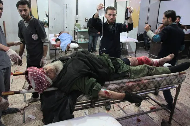 A Syrian man receives medical attention at a makeshift clinic following a reported airstrike by Syrian government forces, in the rebel-held town of Douma in Syria's eastern Ghouta region, on November 26, 2017. Syrian regime air strikes and artillery fire killed 23 civilians across the rebel-held Eastern Ghouta region outside the capital Damascus, the Britain-based Syrian Observatory for Human Rights monitor said. (Photo by Hamza Al-Ajweh/AFP Photo)