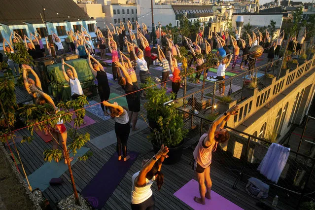People take part in a yoga session on the roof of Lucerna Palace as the sun goes down on July 1, 2020 in Prague. (Photo by Michal Cizek/AFP Photo)